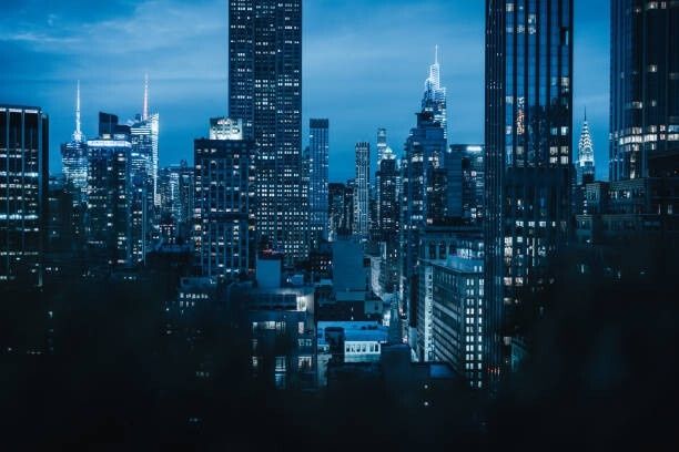 Nächtliche Skyline mit beleuchteten Wolkenkratzern im blauen Dämmerlicht