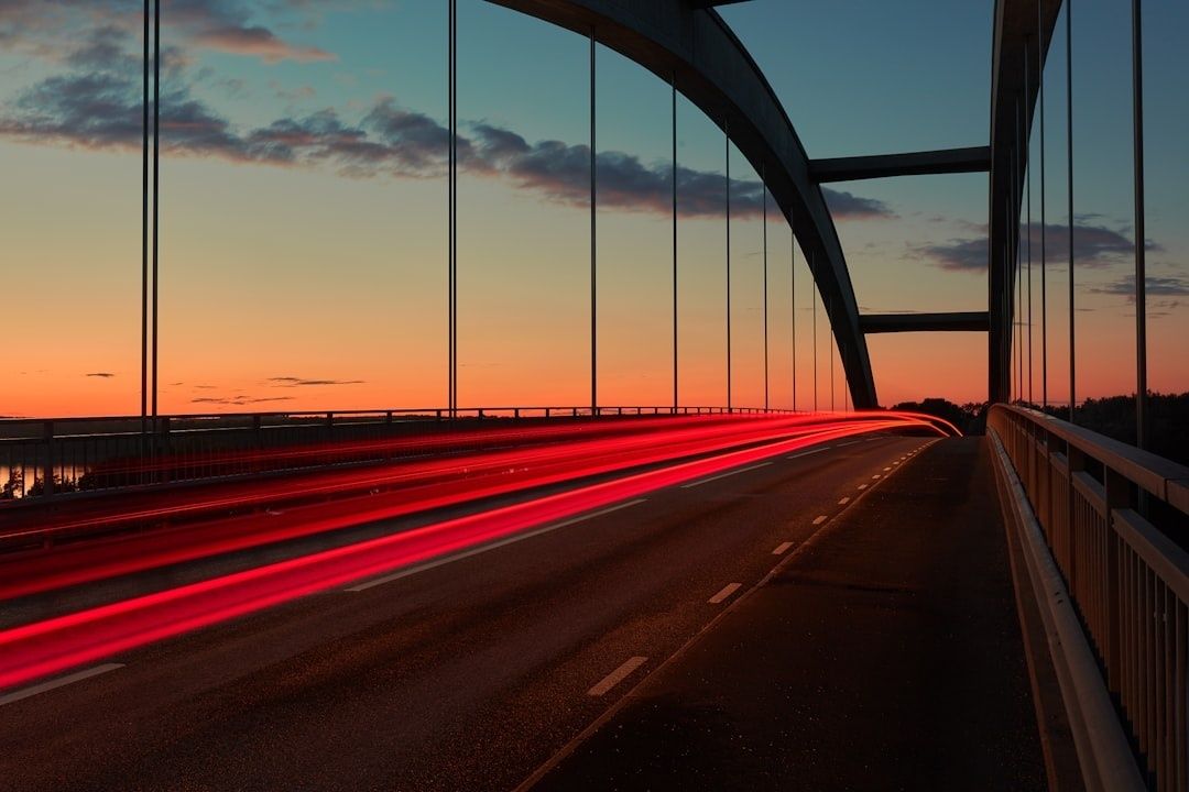 Brücke in der Dämmerung mit roten Lichtspuren und blauem Abendhimmel